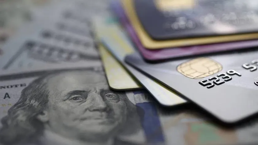 Stack of business credit cards on currency representing credit card stacking capacity