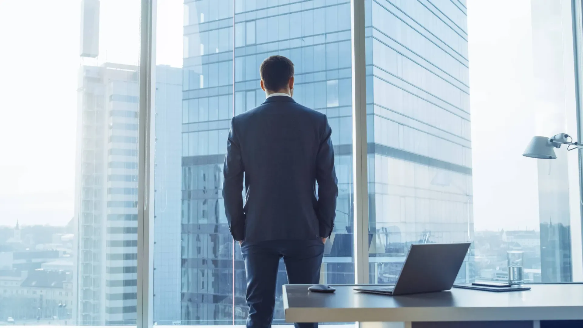 Established business leader looking across a city skyline while planning the next stage