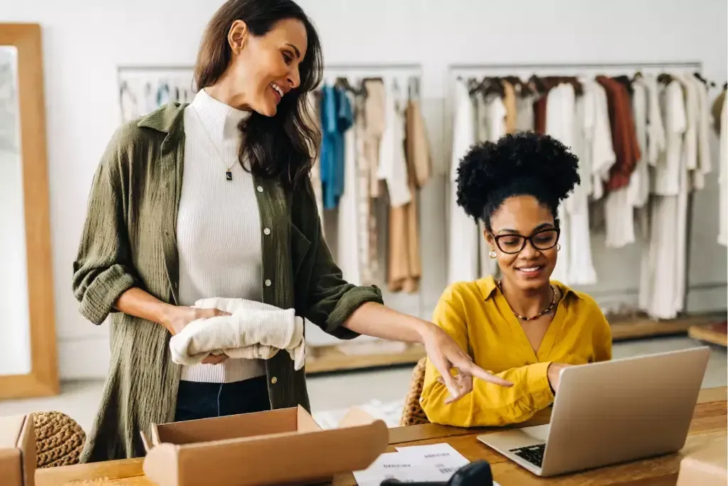 Retail team organizing inventory together in a boutique stockroom