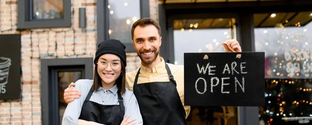 Two shop owners outside a storefront representing expansion and a defined term-loan plan
